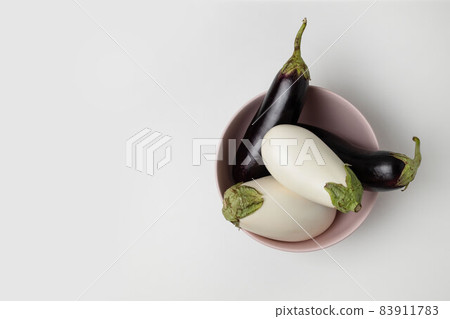 Plate with raw ripe eggplants on grey background, top view. Harvest concept 83911783