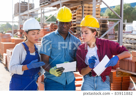 Group of workers discussing order list at warehouse 83911882