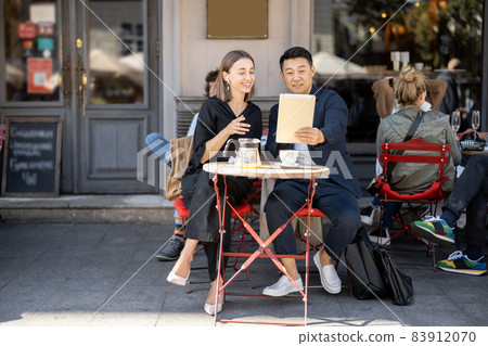 People having video call on digital tablet at cafe 83912070