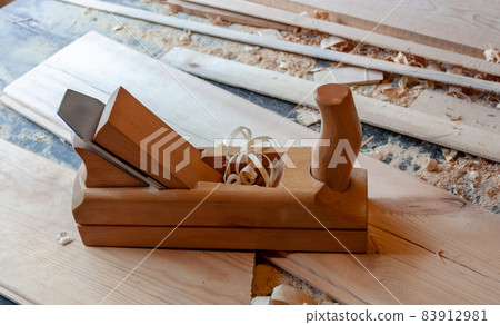Boards of light wood, wooden jointer close-up. Sawdust, shavings 83912981