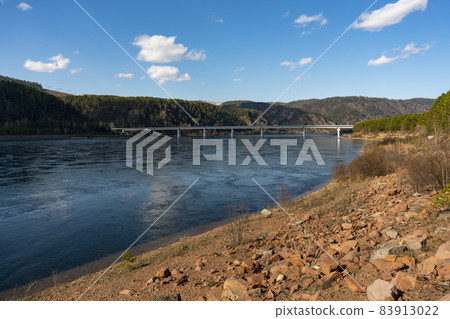 Long concrete bridge over the river on massive pillars. Long concrete bridge over the river on massive pillars. 83913022