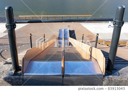 Childrens iron slide on the river embankment. 83913043