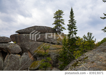 The top of the stone tale against the background of the cloudy sky. 83913071