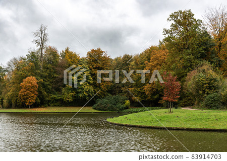 View over the water pond and colorful autumn trees of the city park View over the water pond and colorful autumn trees of the city park 83914703