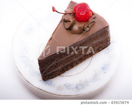 Chocolate cake with topping cherry in ceramic plate. Delicious cuisine dessert over white background Chocolate cake with topping cherry in ceramic plate. Delicious cuisine dessert over white background 83915674