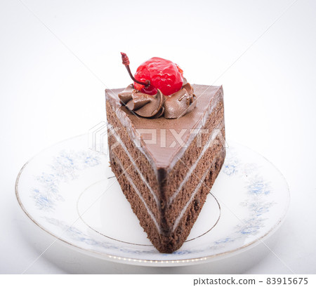 Chocolate cake with topping cherry in ceramic plate. Delicious cuisine dessert over white background Chocolate cake with topping cherry in ceramic plate. Delicious cuisine dessert over white background 83915675
