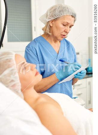 Skillful cosmetologist consulting young woman in medical esthetic office Skillful cosmetologist consulting young woman in medical esthetic office 83916260