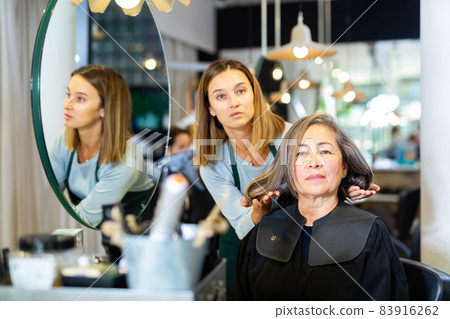 Elderly woman discussing hairstyling with professional hairdresser Elderly woman discussing hairstyling with professional hairdresser 83916262