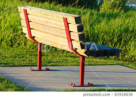 A park bench on a concrete base A park bench on a concrete base 83916636