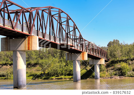 A foot bridge over a river in summer 83917632