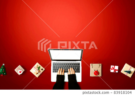 Person using a laptop computer with Christmas gift boxes 83918104