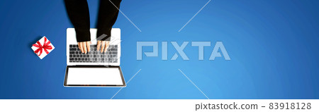 Person using a laptop computer with a gift box Person using a laptop computer with a gift box 83918128
