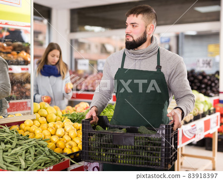 Positive seller in apron working in vegetables market Positive seller in apron working in vegetables market 83918397