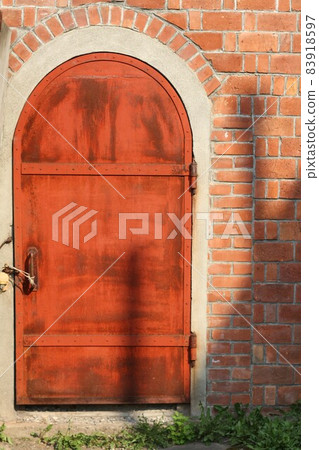 Cute little iron door in a brick warehouse Cute little iron door in a brick warehouse 83918597