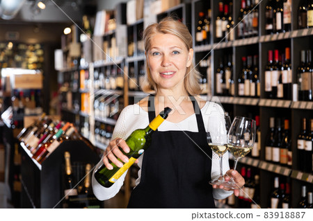 Woman owner of winery inviting to tasting wine Woman owner of winery inviting to tasting wine 83918887