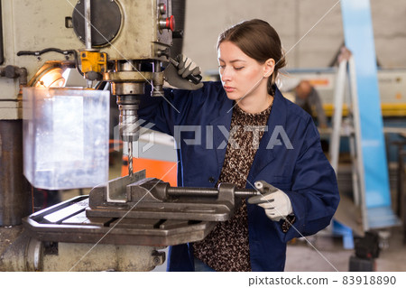 Woman drilling steel structures on drill press Woman drilling steel structures on drill press 83918890