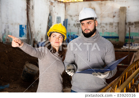 Engineers discussing blueprint at construction site Engineers discussing blueprint at construction site 83920316