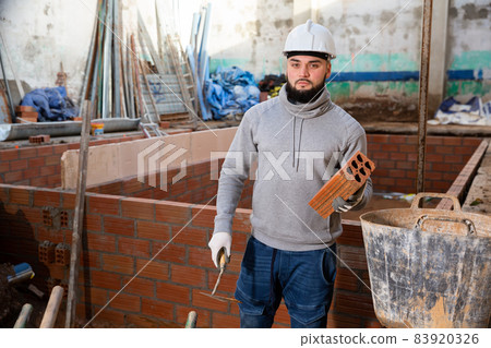 Bricklayer installing brick wall Bricklayer installing brick wall 83920326