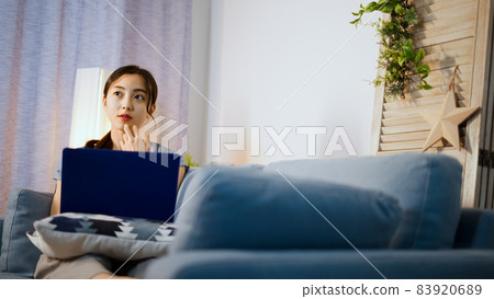 使用便攜式計算機的一個少婦在沙發 83920689