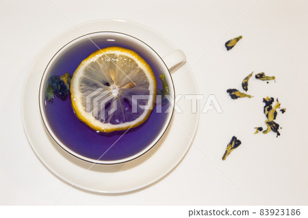 The mood color is blue - blue tea with lemon in a white mug, which stands on a white saucer and 83923186