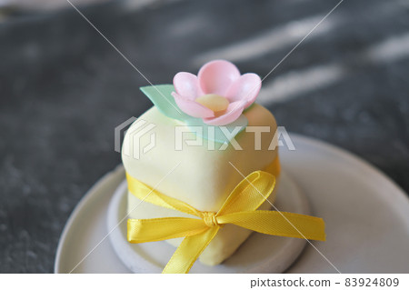 top view of mini cake decorated with edible flowera ns leaves made of rice paper. sweet treat for autumn halloween selebration, ribbon decor. icing cover. top view of mini cake decorated with edible flowera ns leaves made of rice paper. sweet treat for autumn halloween selebration, ribbon decor. icing cover. 83924809