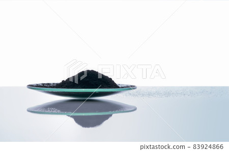 Carbon Charcoal Powder in Chemical Watch Glass. Close up chemical ingredient on white laboratory table. Side View 83924866