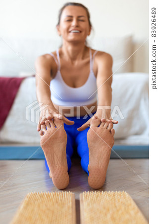 Young woman after standing on sadhu board. Sadhu foot board. Yoga relaxation practice training. Focus on feet. 83926489