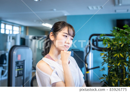 Female in a gym (thinking / worried) 83926775