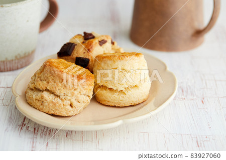 Various types of scones and mugs 83927060