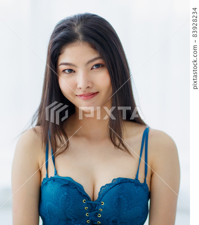 Portrait of beautiful young naughty sexy Asian girl with long hairs and lovely blue bra standing with seductively smile with happy in bright morning. Portrait of beautiful young naughty sexy Asian girl with long hairs and lovely blue bra standing with seductively smile with happy in bright morning. 83928234