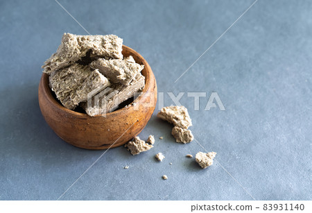 Sunflower halva in a clay plate on a gray background. Made from sunflower seeds. 83931140