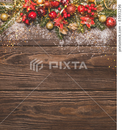 Festive Christmas background red balls green branches spruce serpentine sequins wooden dark background. Festive Christmas background red balls green branches spruce serpentine sequins wooden dark background. 83931296