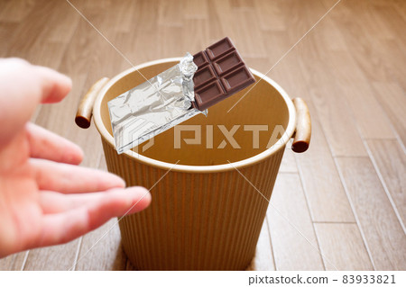 Throw the chocolate bar into the trash can with the image of cutting off sweets Throw the chocolate bar into the trash can with the image of cutting off sweets 83933821