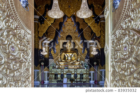 Looking through the beautiful architecture temple door of The golden buddha image within Wat Phra That Doi Phra Chan in Lampang. 83935032