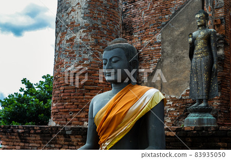 Ancient Buddha statue and the wall made by old red brick background at Wat Thammikarat of Ayutthaya Thailand. Ancient Buddha statue and the wall made by old red brick background at Wat Thammikarat of Ayutthaya Thailand. 83935050