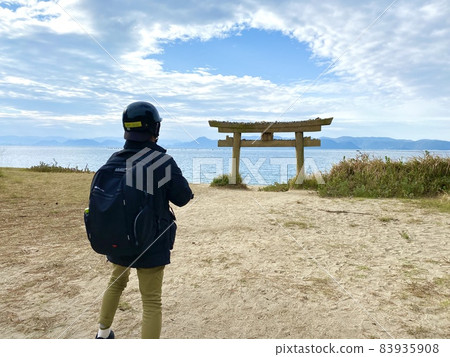 A man looking at the empty blue sky above the torii that was buried and lowered A man looking at the empty blue sky above the torii that was buried and lowered 83935908