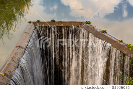 Turbid water in the check dam overflows into the spillway, Man-made Water falling. Turbid water in the check dam overflows into the spillway, Man-made Water falling. 83936085