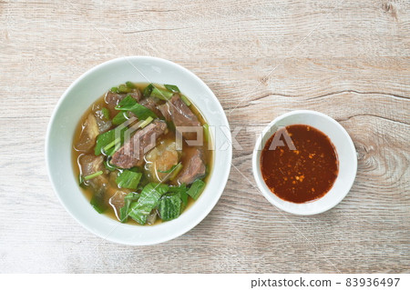 boiled braised beef meat and tendon in herb brown soup on bowl dipping spicy chili sauce boiled braised beef meat and tendon in herb brown soup on bowl dipping spicy chili sauce 83936497