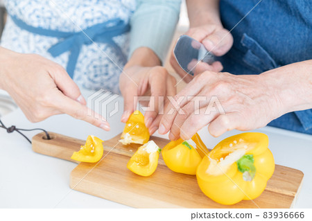 Up the hand of a middle-aged man who cuts paprika in the kitchen 83936666