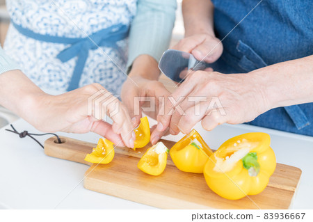 Up the hand of a middle-aged man who cuts paprika in the kitchen 83936667