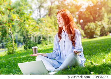 Young redhead woman meditates in lotus pose Young redhead woman meditates in lotus pose 83936684