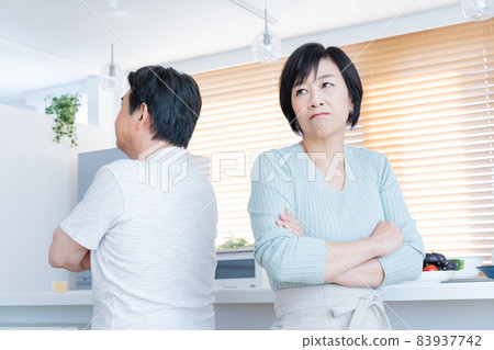 Middle-aged couple sitting back to back at the kitchen counter, middle-aged divorce Middle-aged couple sitting back to back at the kitchen counter, middle-aged divorce 83937742