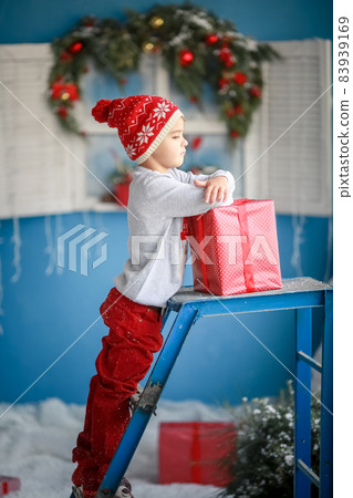 A child in a red hat alone holds a box of red on new year's day 83939169