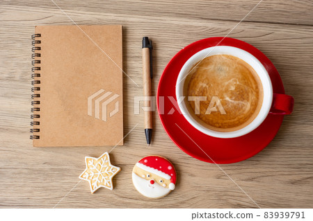 Blank notebook, black coffee cup, Christmas cookies and pen on wood table, Top view and copy space. Xmas, Happy New Year, Goals, Resolution, To do list, Strategy and Plan concept Blank notebook, black coffee cup, Christmas cookies and pen on wood table, Top view and copy space. Xmas, Happy New Year, Goals, Resolution, To do list, Strategy and Plan concept 83939791