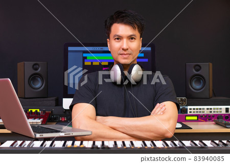 portrait of smiling asian professional music producer, composer, sound engineer, arranger in recording studio 83940085