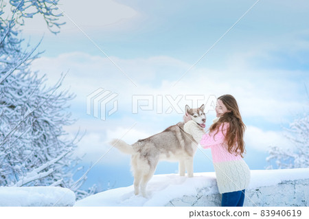 Woman on a winter walk with a husky dog Woman on a winter walk with a husky dog 83940619