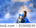 A woman with a husky dog walking on winter snow-covered mountains 83940630
