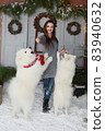 A young girl with a dog near the Christmas tree 83940632