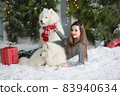 A young girl with a dog near the Christmas tree 83940634