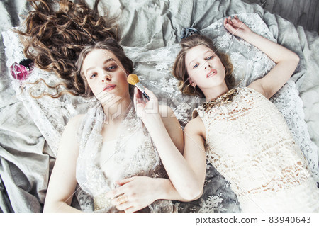 two pretty twin sister blond curly hairstyle girl in luxury house interior together, rich young people concept two pretty twin sister blond curly hairstyle girl in luxury house interior together, rich young people concept 83940643